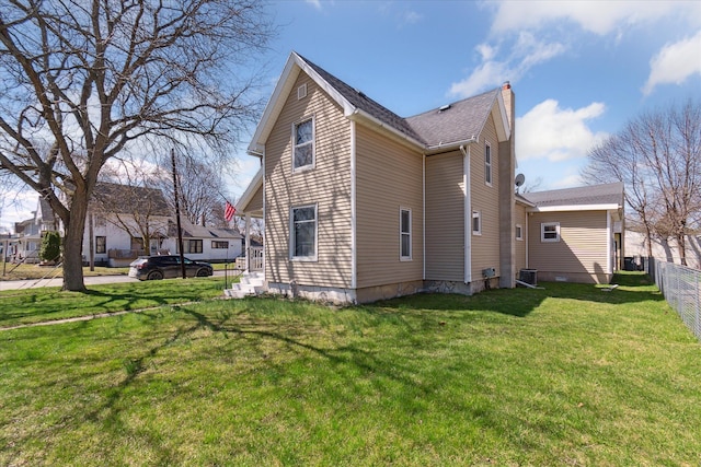 701 N Saginaw St, Durand, MI 48429 - view of home's exterior featuring fence, a yard, a chimney, and cooling unit