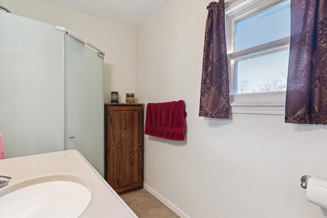 701 N Saginaw St, Durand, MI 48429 - bathroom with baseboards, a sink, and a shower with door
