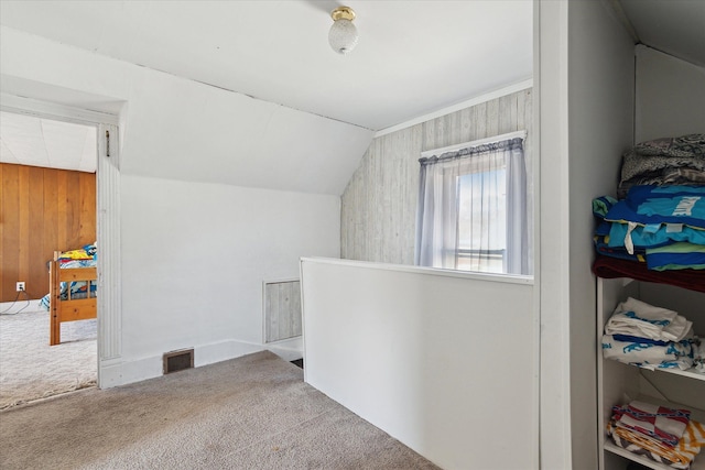701 N Saginaw St, Durand, MI 48429 - additional living space with carpet floors, lofted ceiling, wooden walls, and visible vents
