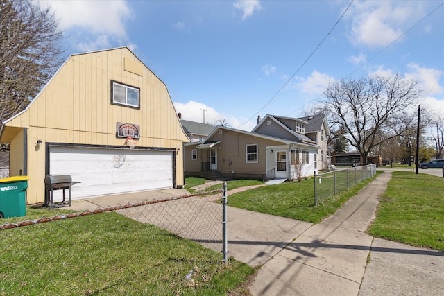 701 N Saginaw St, Durand, MI 48429 - view of front of property featuring fence, a gambrel roof, a front lawn, a detached garage, and driveway