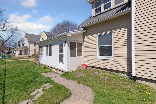 701 N Saginaw St, Durand, MI 48429 - view of side of home with a lawn, a sunroom, and roof with shingles