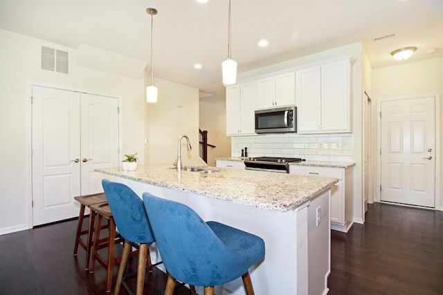 kitchen featuring dark wood-style flooring, a sink, appliances with stainless steel finishes, and visible vents