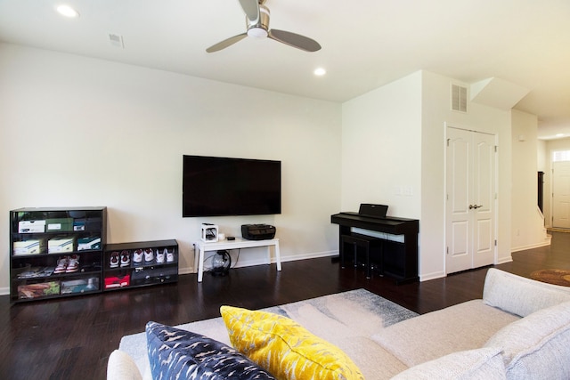 living area featuring baseboards, visible vents, wood finished floors, and ceiling fan