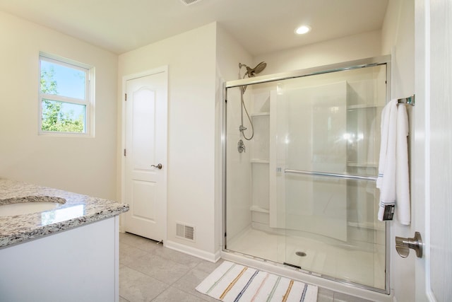 bathroom featuring tile patterned floors, a shower stall, vanity, baseboards, and visible vents