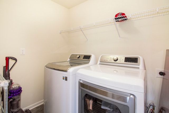 laundry area with baseboards, laundry area, and washing machine and dryer