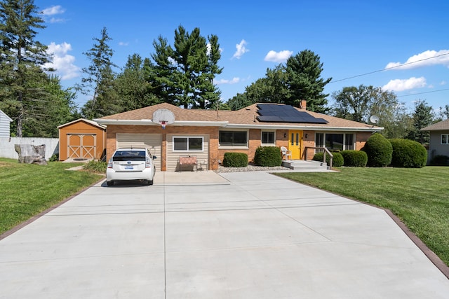 2250 Saines Manor Dr, Jackson, MI 49201 - single story home featuring roof mounted solar panels, concrete driveway, a storage shed, an attached garage, and a front lawn