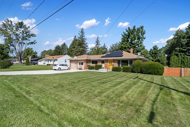 2250 Saines Manor Dr, Jackson, MI 49201 - single story home featuring fence, solar panels, a front yard, and concrete driveway