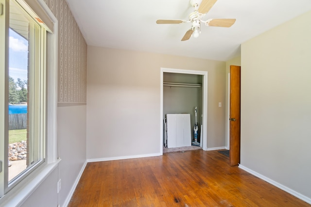 2250 Saines Manor Dr, Jackson, MI 49201 - unfurnished bedroom with baseboards, wood finished floors, a ceiling fan, and multiple windows