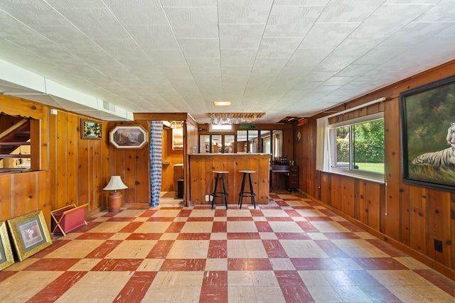 2250 Saines Manor Dr, Jackson, MI 49201 - interior space with tile patterned floors, wooden walls, and a bar