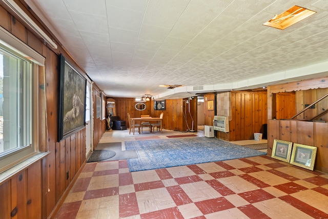 2250 Saines Manor Dr, Jackson, MI 49201 - interior space featuring tile patterned floors, visible vents, heating unit, and wooden walls
