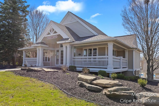 view of front of home featuring roof with shingles and a porch