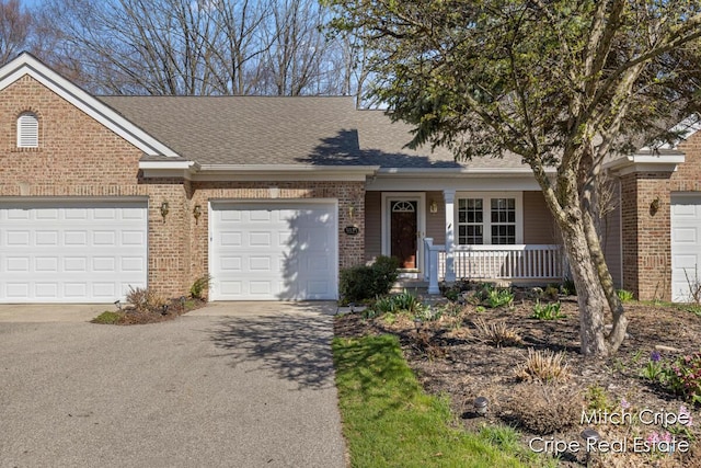 view of front of house featuring brick siding, a porch, driveway, and roof with shingles
