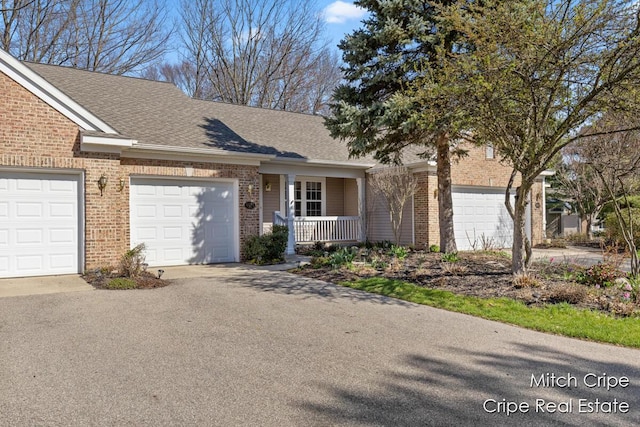 view of front facade featuring a porch, a garage, brick siding, aphalt driveway, and roof with shingles