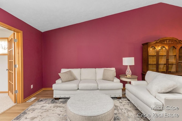 living area featuring wood finished floors, visible vents, and baseboards
