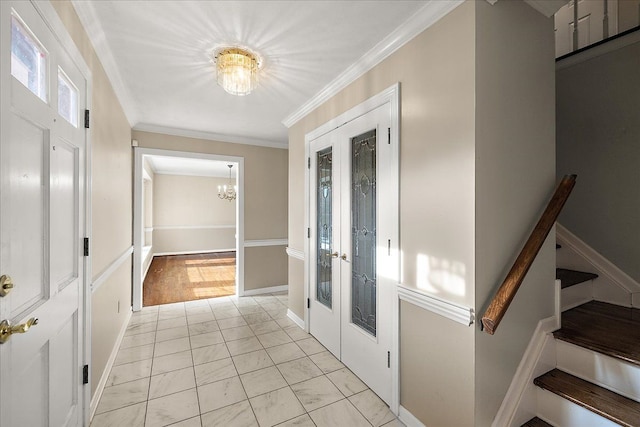 entrance foyer with a notable chandelier, crown molding, marble finish floor, stairs, and french doors