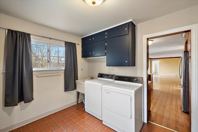 laundry room featuring baseboards, cabinet space, separate washer and dryer, and tile patterned flooring