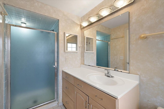 bathroom featuring a shower stall, a textured wall, and vanity