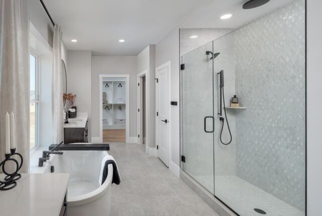 bathroom featuring a stall shower, tile patterned flooring, a freestanding bath, and plenty of natural light