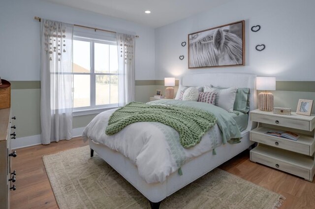 bedroom featuring wood finished floors, baseboards, recessed lighting, and multiple windows