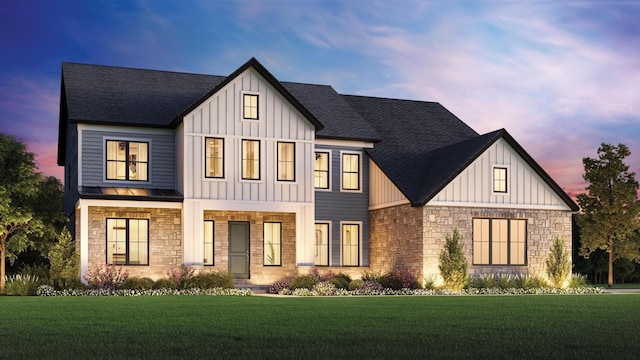 modern farmhouse style home featuring board and batten siding, a yard, and stone siding