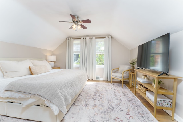 bedroom featuring visible vents, wood finished floors, lofted ceiling, baseboards, and ceiling fan