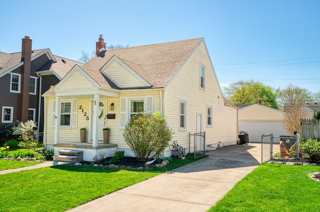 bungalow featuring a porch, an outdoor structure, a front lawn, and a garage