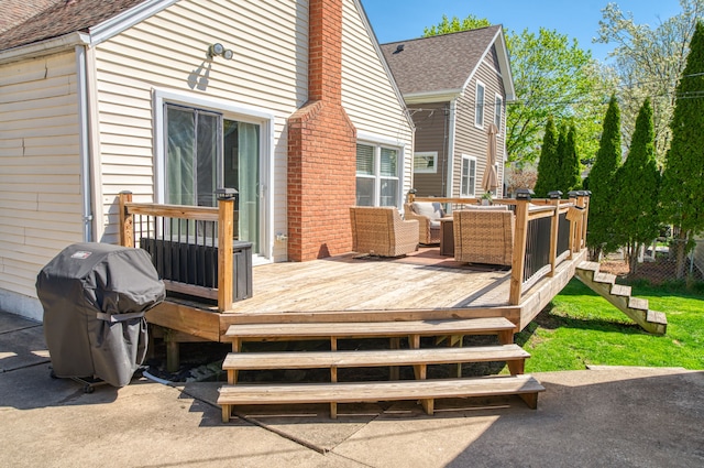 wooden deck with an outdoor hangout area and grilling area