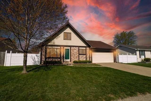 traditional-style house with a garage, a yard, brick siding, concrete driveway, and fence