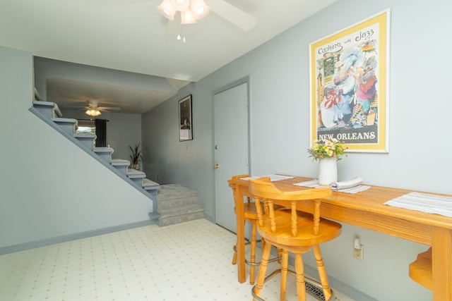 dining area featuring stairs, ceiling fan, and light colored carpet