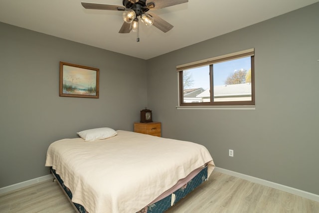 bedroom featuring ceiling fan, baseboards, and light wood-style floors