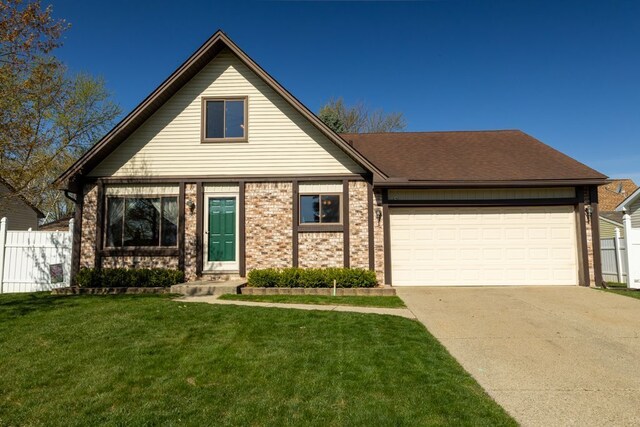 view of front of home with fence, a front lawn, driveway, and an attached garage