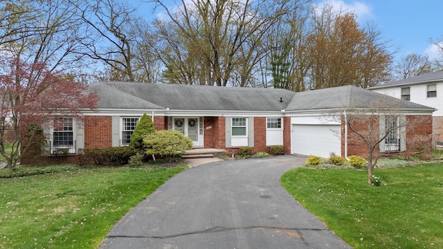 ranch-style house featuring a front yard, a garage, aphalt driveway, and brick siding