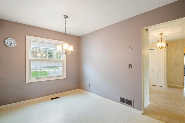 unfurnished room with a notable chandelier, baseboards, and visible vents