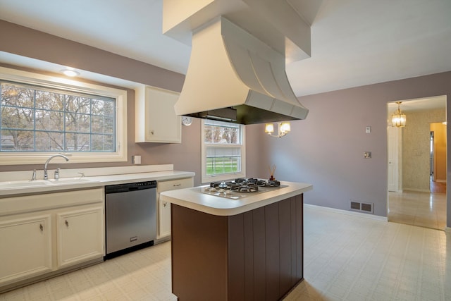 kitchen featuring a sink, island range hood, light countertops, dishwasher, and white gas cooktop