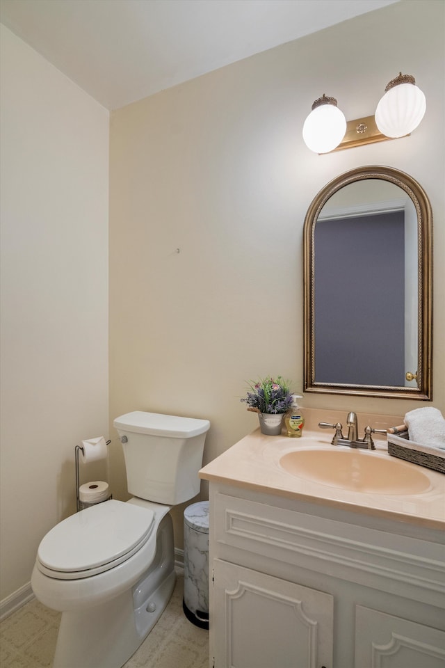 half bath featuring toilet, vanity, and baseboards