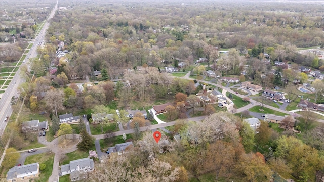 drone / aerial view with a wooded view and a residential view