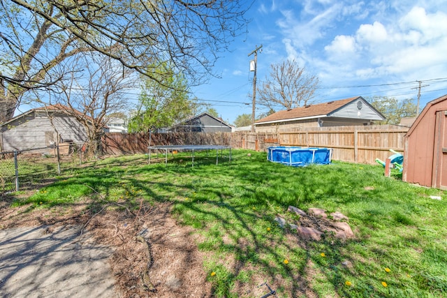 8127 Continental Ave, Warren, MI 48089 - view of yard featuring a fenced in pool, a storage shed, a trampoline, and a fenced backyard