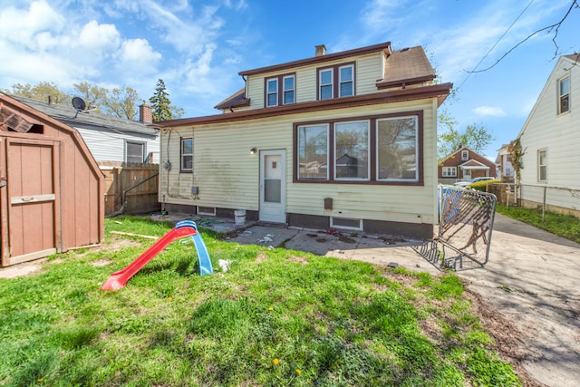8127 Continental Ave, Warren, MI 48089 - rear view of house with an outdoor structure, a storage unit, a fenced backyard, and a chimney