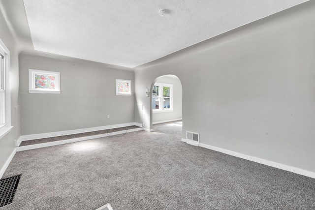 8127 Continental Ave, Warren, MI 48089 - spare room featuring visible vents, baseboards, carpet, a textured ceiling, and arched walkways