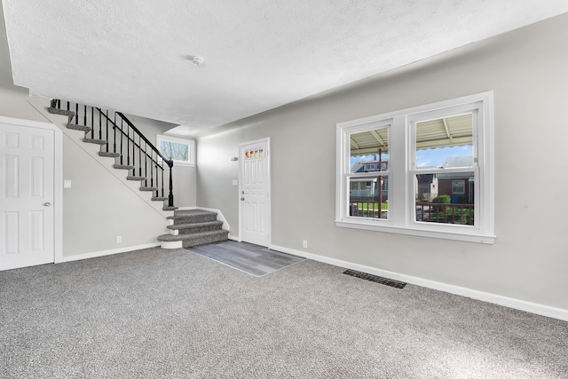 8127 Continental Ave, Warren, MI 48089 - carpeted foyer entrance with a textured ceiling, visible vents, stairway, and baseboards