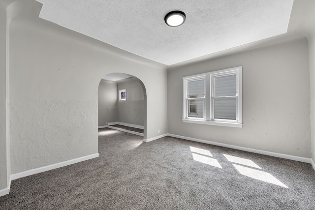 8127 Continental Ave, Warren, MI 48089 - unfurnished room featuring carpet flooring, a textured wall, a textured ceiling, baseboards, and arched walkways