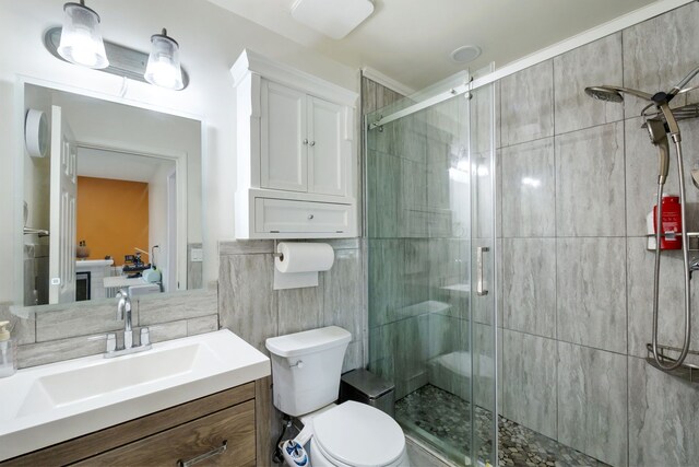 full bathroom with toilet, tile walls, a shower stall, and vanity