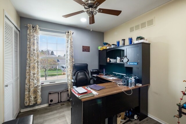 office area featuring baseboards, a ceiling fan, wood finished floors, and visible vents