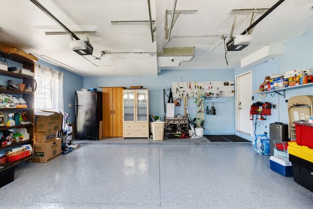 garage with a garage door opener and freestanding refrigerator