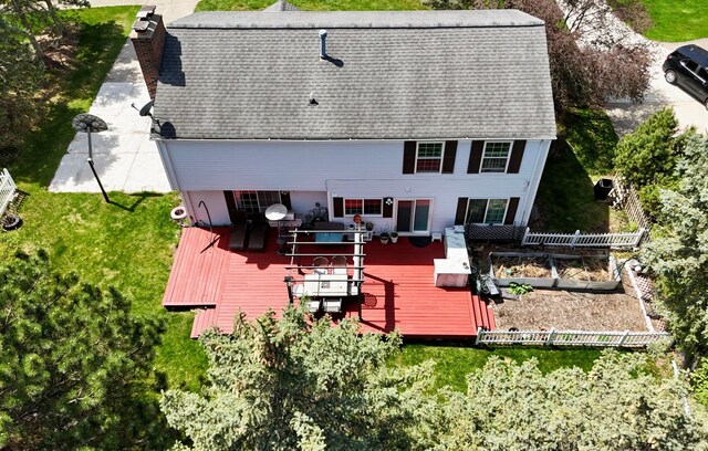 rear view of property featuring roof with shingles, a wooden deck, and a chimney