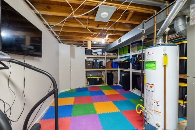 unfinished basement with tile patterned floors, gas water heater, and visible vents