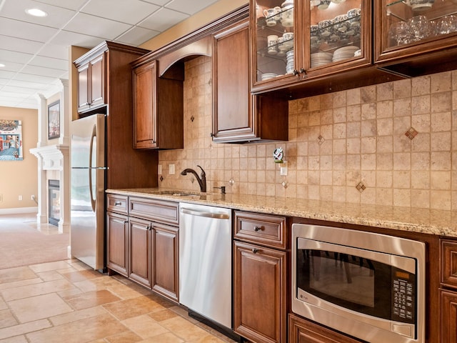 810 Highwood Dr, Bloomfield Hills, MI 48304 - kitchen with appliances with stainless steel finishes, tasteful backsplash, light stone countertops, and glass insert cabinets