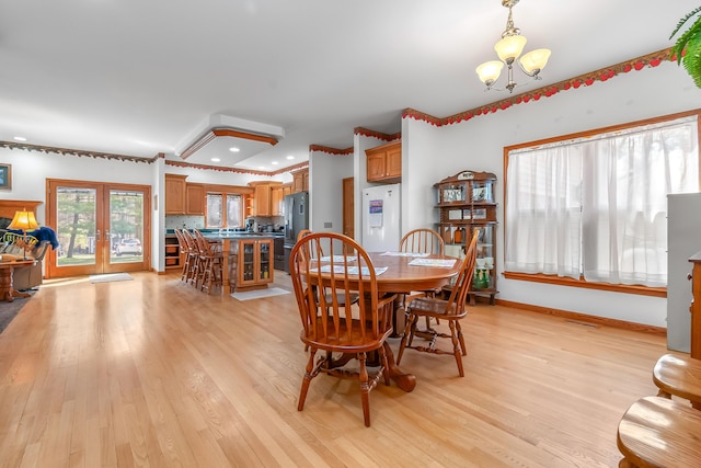 3553 Alpine Ct, Hillsdale, MI 49242 - dining room featuring baseboards, an inviting chandelier, french doors, and light wood-style flooring