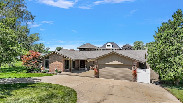 37337 Lakeshore Dr, Harrison Township, MI 48045 - view of front of home with a front yard, brick siding, driveway, roof with shingles, and an attached garage