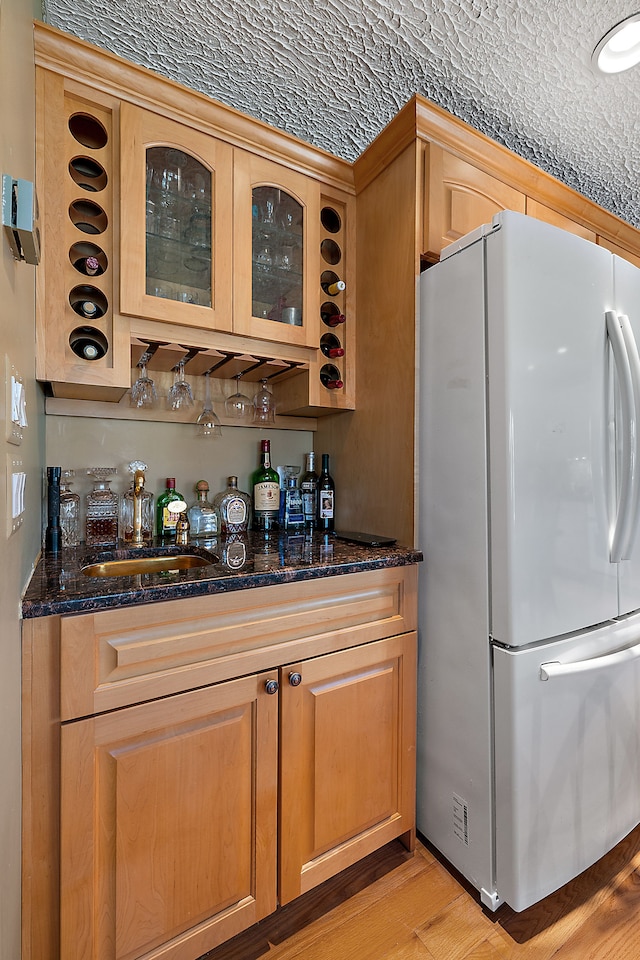 37337 Lakeshore Dr, Harrison Township, MI 48045 - bar featuring light wood-style flooring, a bar, freestanding refrigerator, and a sink
